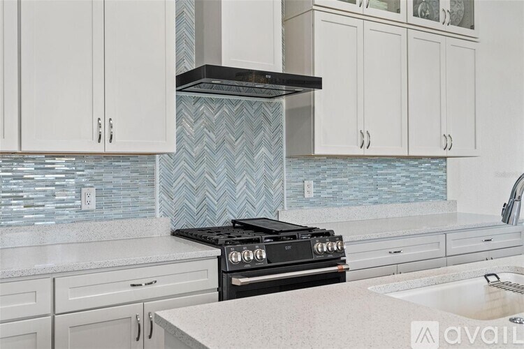 A kitchen with a black stove top oven and white cabinets.