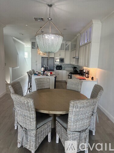 A dining room with a round table and chairs.