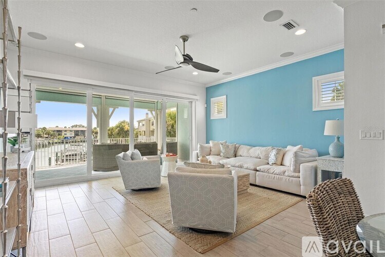 A living room with a white sofa and a wicker chair.