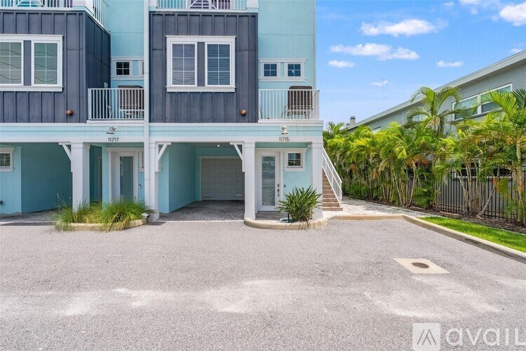A two-story building with a balcony and a driveway in front.