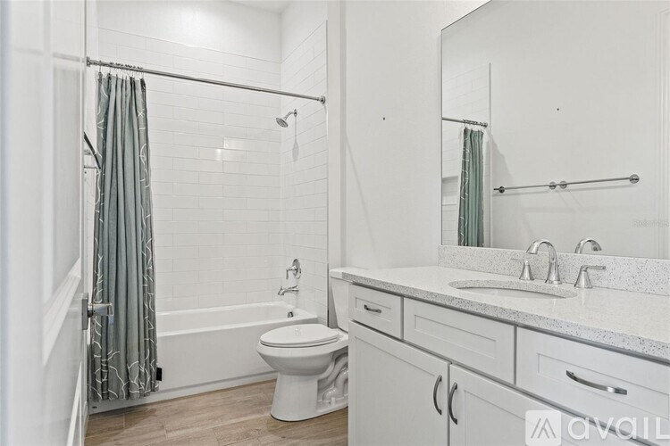 A white bathroom with a toilet, sink, and shower.