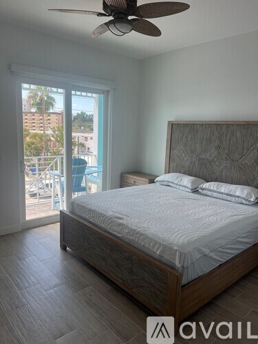 A bedroom with a large bed and a ceiling fan.