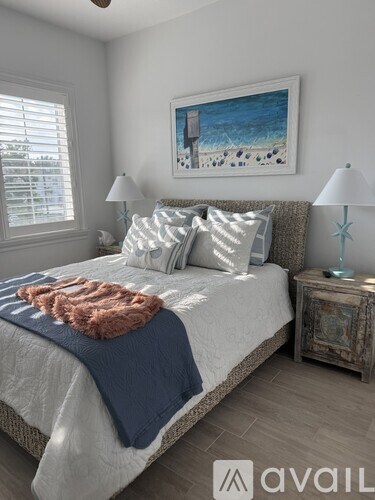 A bedroom with a large bed and a ceiling fan.