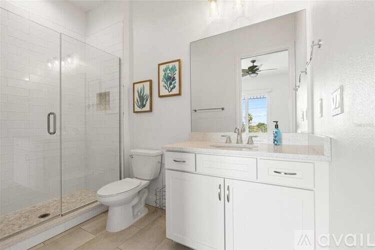 A white bathroom with a toilet, sink, and mirror.