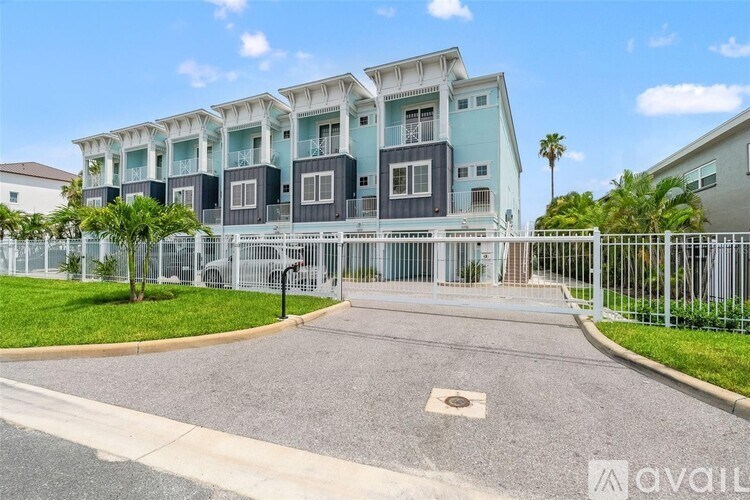 A modern building with a white fence and a gate in front.