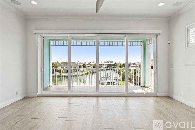 A spacious room with a view of a waterfront area through the sliding glass doors.