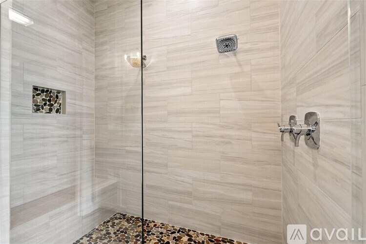A bathroom with a walk-in shower and a tiled floor.