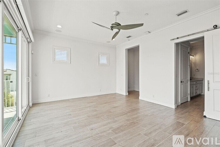 A spacious room with a ceiling fan and lighting fixtures.