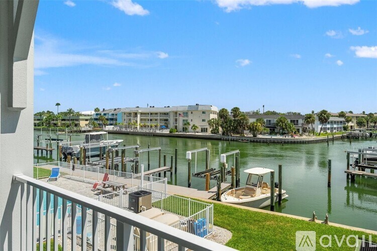 A balcony overlooks a marina with boats and buildings in the distance.