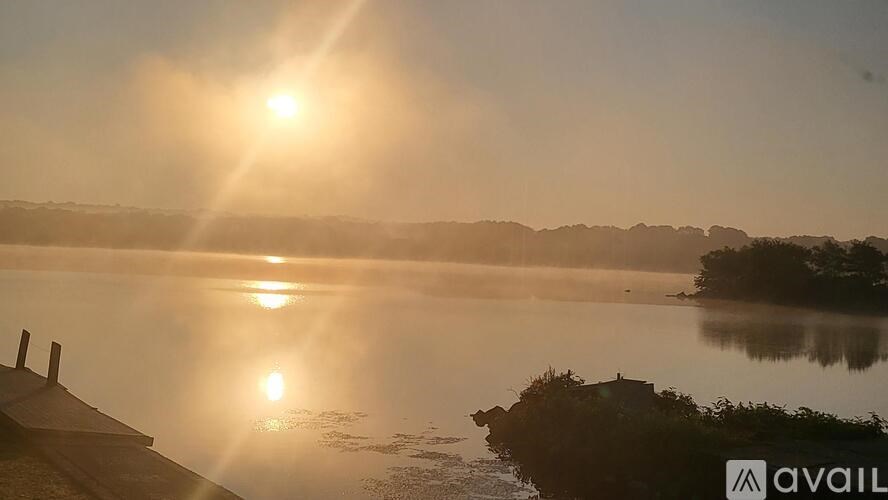 The sun is shining brightly over a calm body of water.