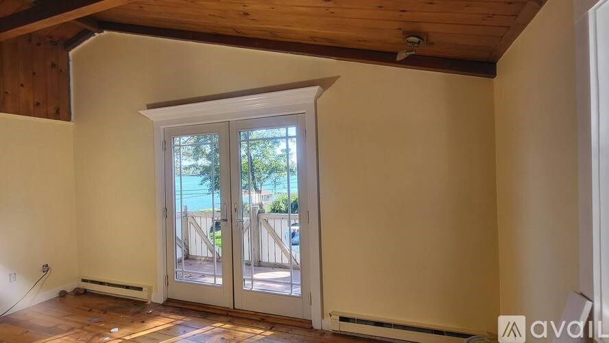 A room with a window and a wooden ceiling.