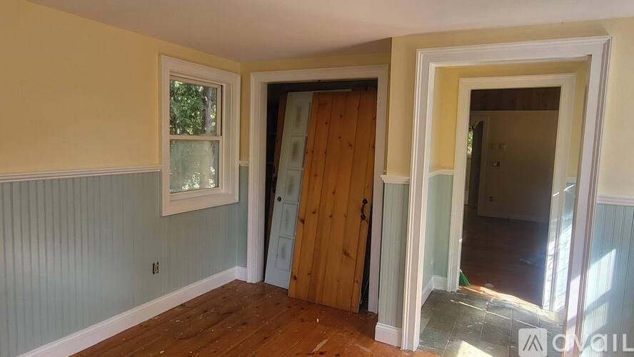 A room with a wooden door and a window.