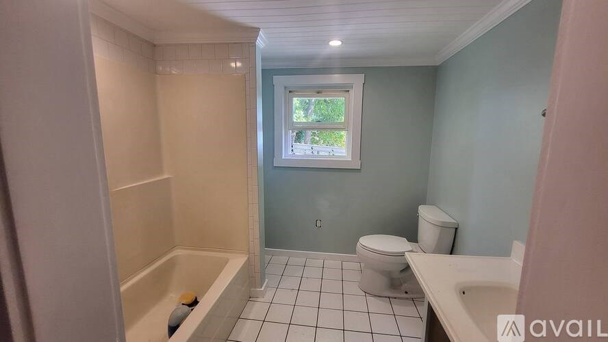 A bathroom with a toilet, sink, and bathtub.