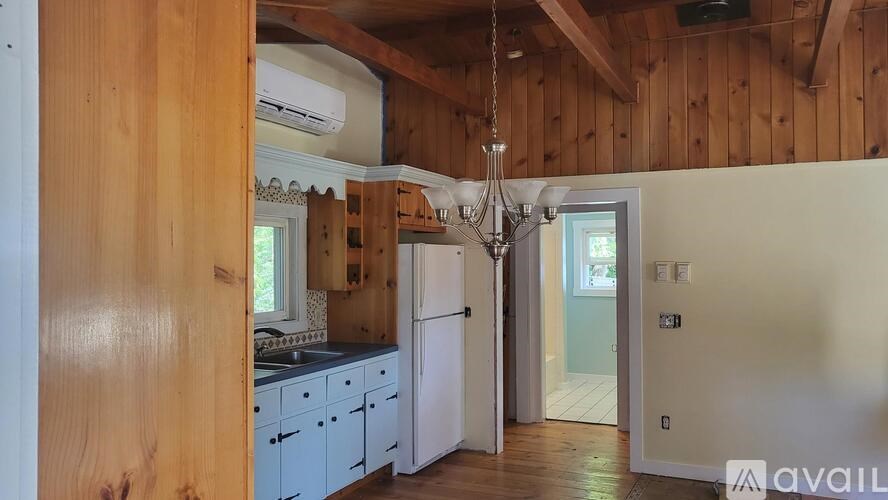 A kitchen with wooden walls and a white refrigerator.