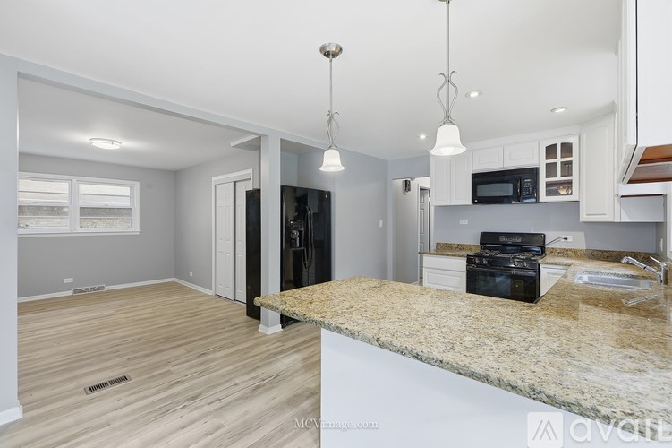 A kitchen with a granite countertop and a microwave above it.