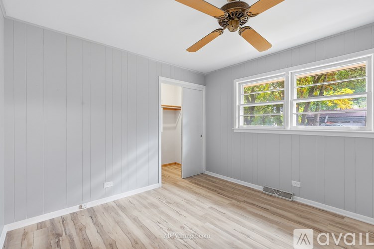 A room with a ceiling fan and a window.