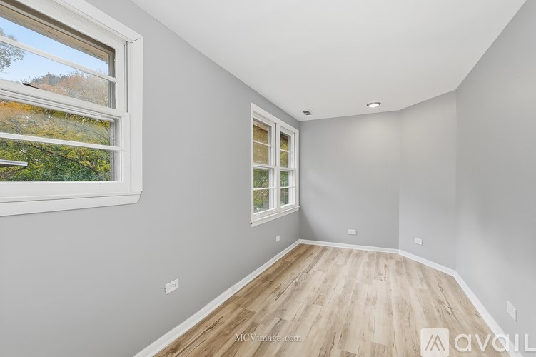 A room with a window and wooden flooring.
