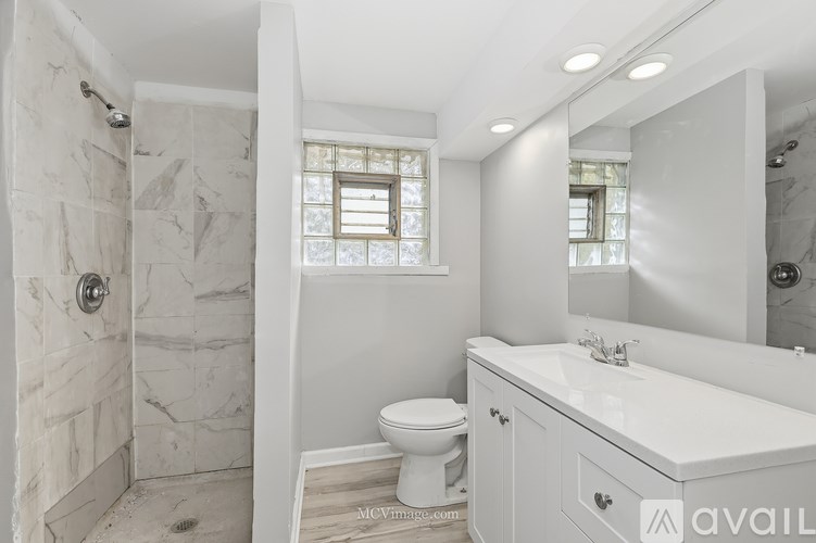 A bathroom with a toilet, sink, and shower.