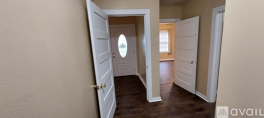 A hallway with a door on the left and another door on the right.