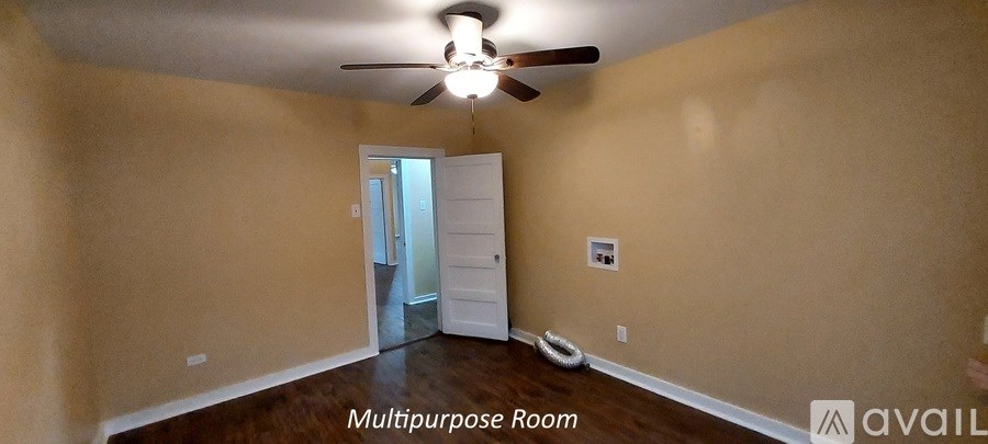 A room with a ceiling fan and a doorway leading to another room.