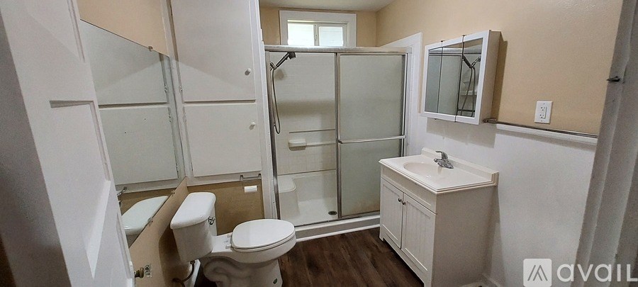 A bathroom with a toilet, sink, and shower.