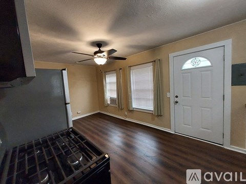 A kitchen area with a black stove top oven and a ceiling fan.