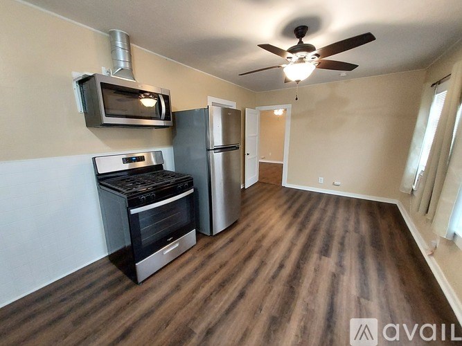 A kitchen with a stove top oven and a microwave is available for rent.