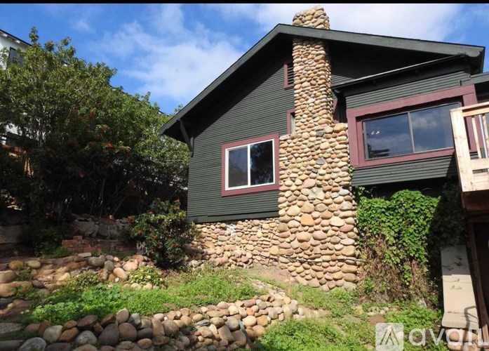 A house with a stone chimney and a window.