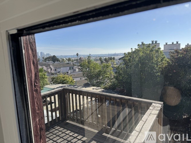 A balcony view of a cityscape with buildings and trees.