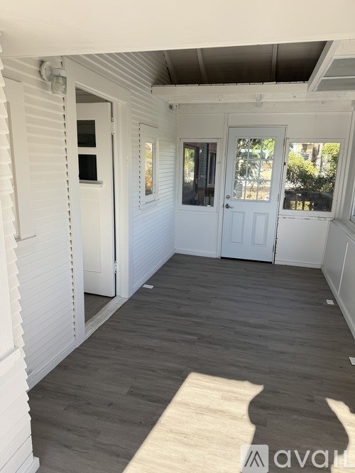 A room with white walls and a wooden floor.