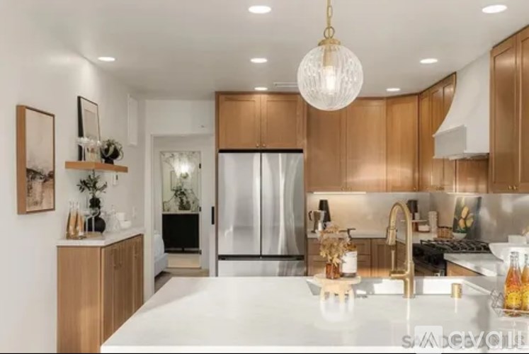 A modern kitchen with wooden cabinets and a white countertop.