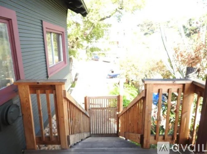 A wooden deck with a railing and a pink window.