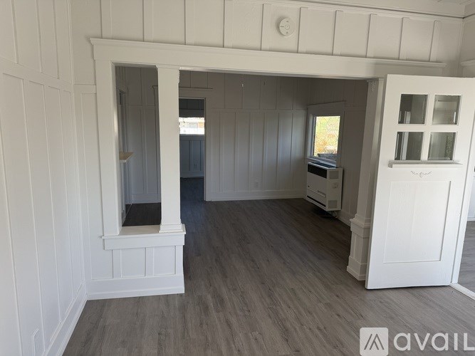 A room with white walls and a window.