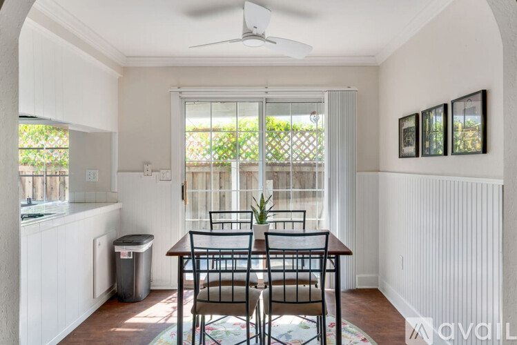 A dining room with a table and chairs and a window.