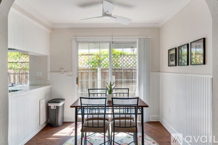 A dining room with a table and chairs and a window.