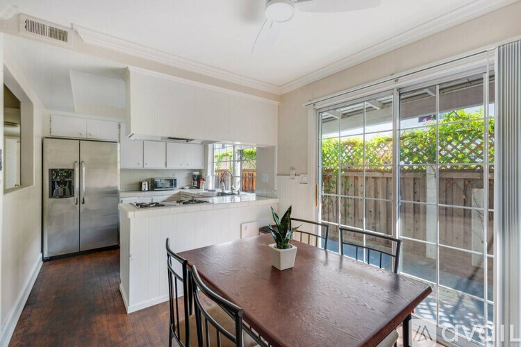A kitchen with a table and chairs in front of a window.