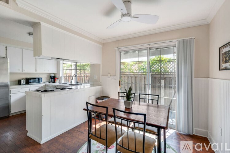 A kitchen with white cabinets and a wooden table.