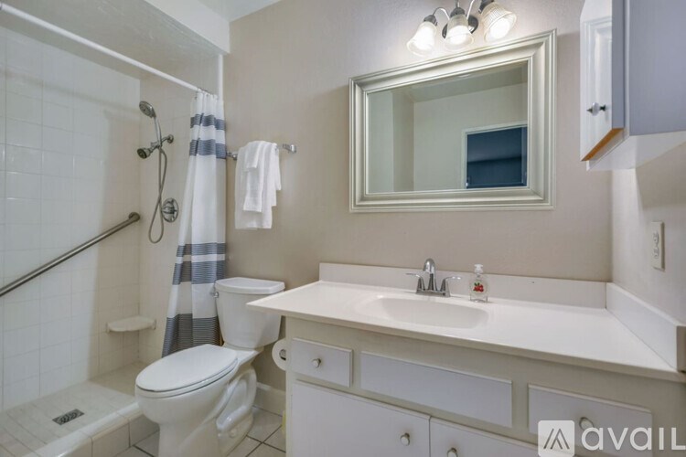 A bathroom with a white toilet, sink, and a mirror.