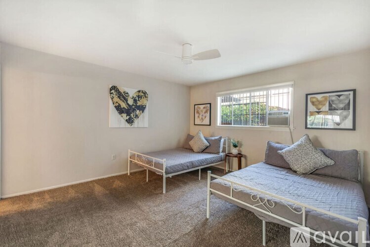 A bedroom with two beds and a ceiling fan.
