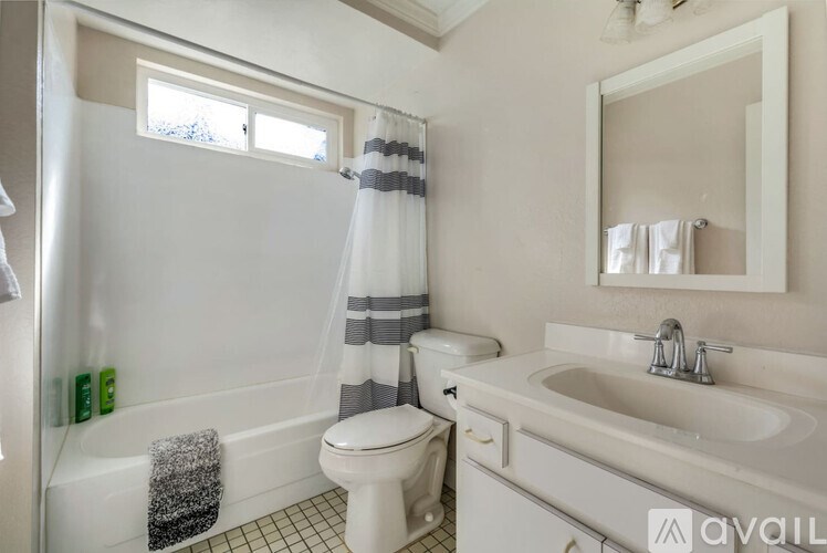 A bathroom with a white toilet, sink, and bathtub with a shower curtain.
