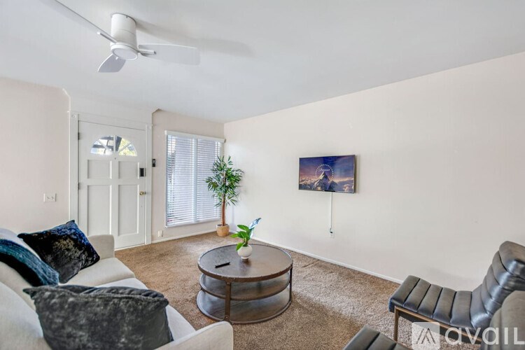 A living room with a couch, chair, and a plant.