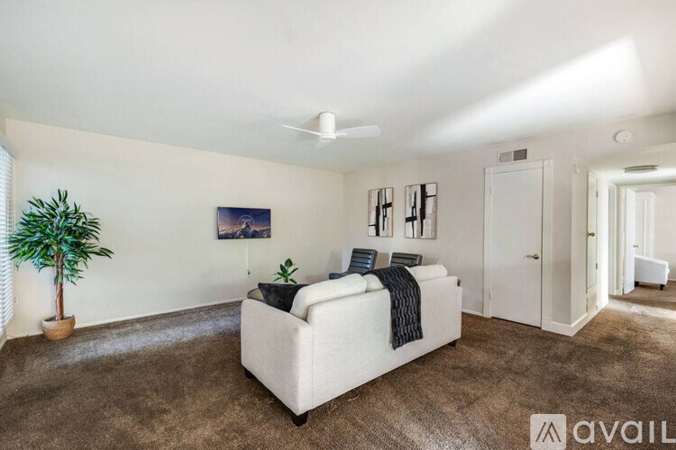 A bedroom with a large bed and a plant.