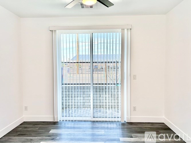 A room with a sliding door leading to a balcony.