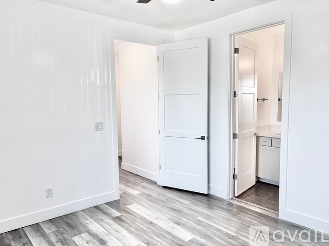 A room with a white door and a white wall.