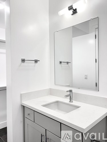 A white sink in a bathroom with a mirror above it.
