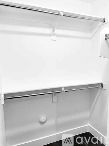 A white closet with a shelf and a hanging rod.