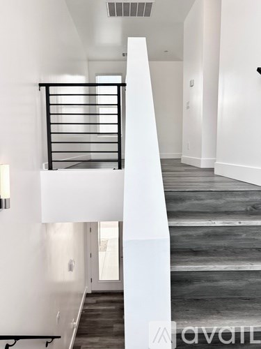 A white staircase with a black railing and wooden steps.