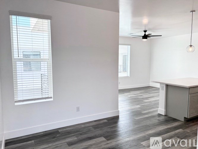 A room with a desk and a window with blinds.