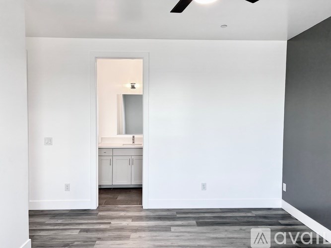 A room with a mirror and a fan on the ceiling.