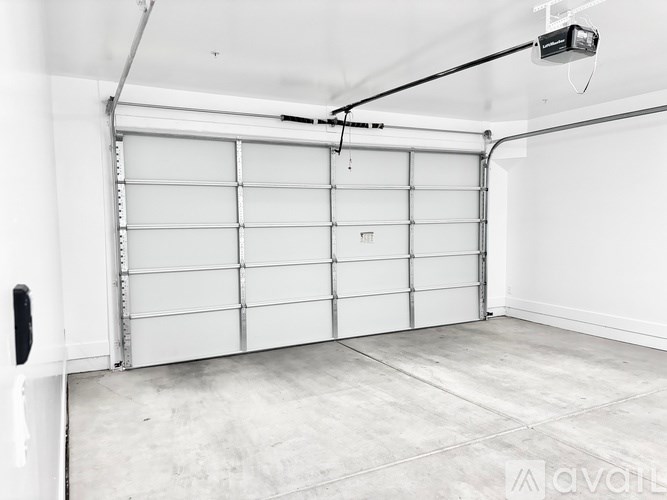 A white garage door is closed and there is a black handle on the left side.